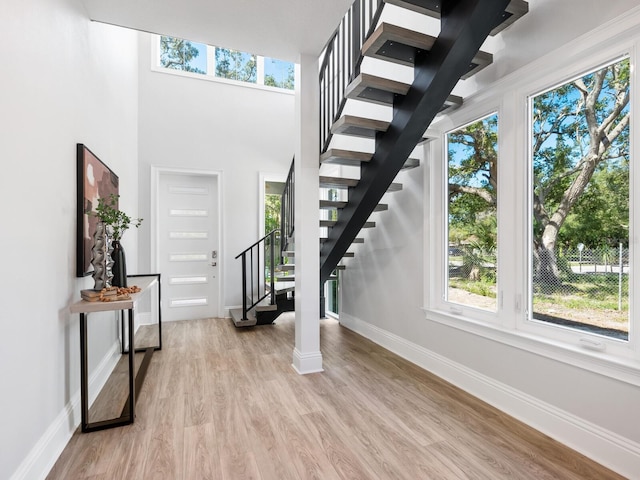 entryway featuring light wood-type flooring and decorative columns