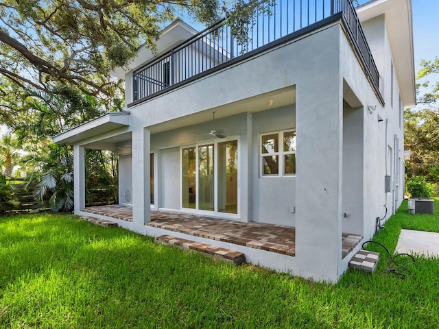 back of house with a patio, a yard, a balcony, ceiling fan, and central air condition unit