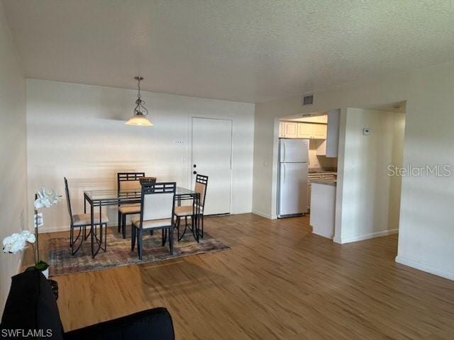 dining room with dark wood-style flooring and baseboards