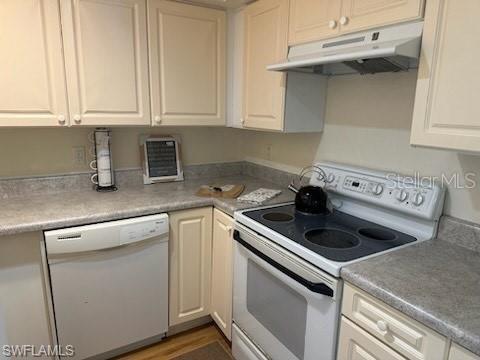 kitchen with white appliances, under cabinet range hood, white cabinetry, and light countertops