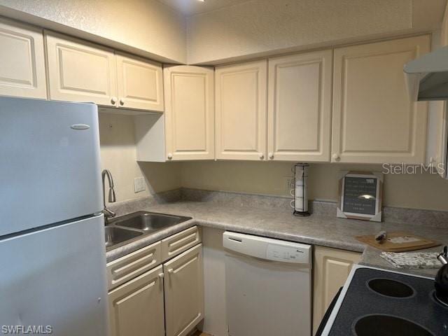 kitchen with white appliances, white cabinets, a sink, and light countertops