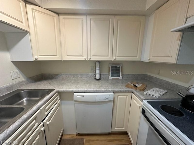 kitchen featuring white appliances, hardwood / wood-style flooring, and white cabinetry