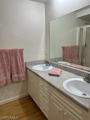 bathroom featuring vanity, an enclosed shower, and wood-type flooring