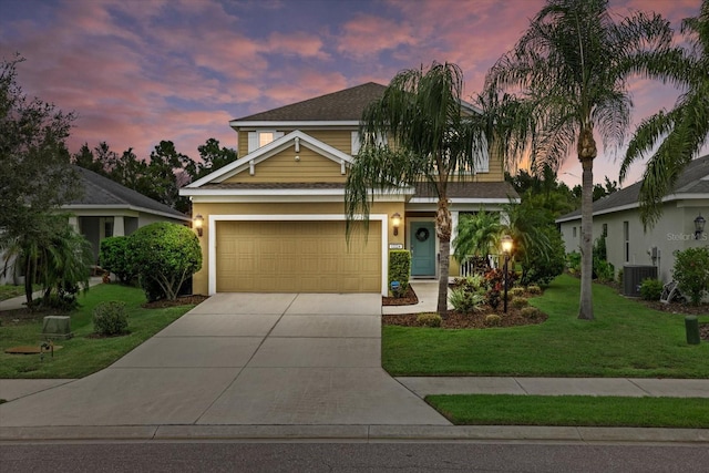 view of front of home featuring central AC unit, a garage, and a lawn