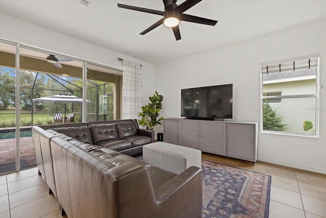 living area with light tile patterned floors, a sunroom, a wealth of natural light, and a ceiling fan