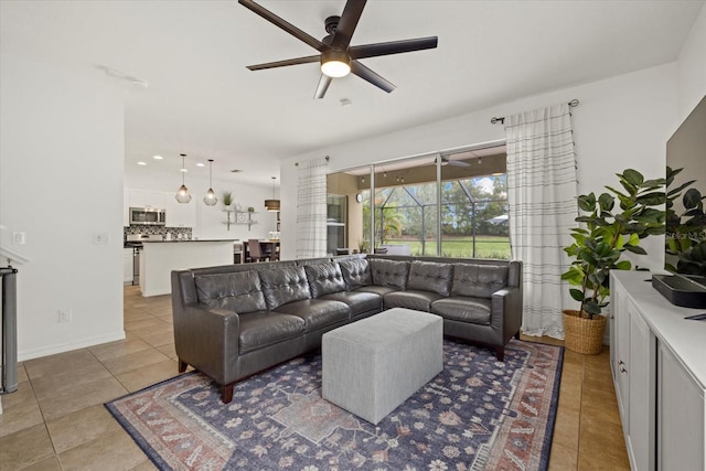 living room featuring a ceiling fan, light tile patterned flooring, and baseboards