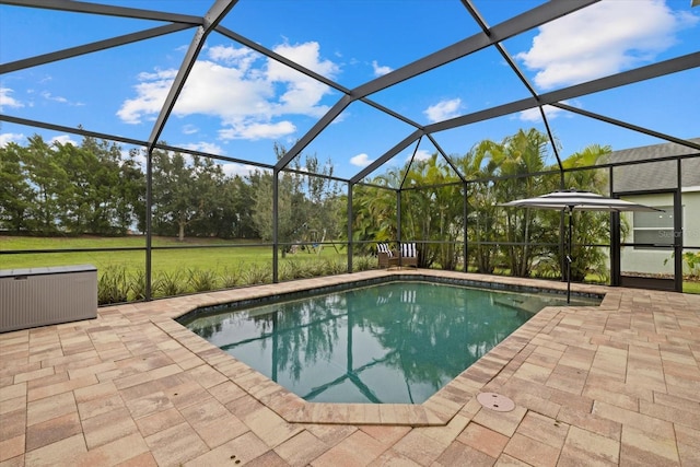 pool featuring glass enclosure and a patio