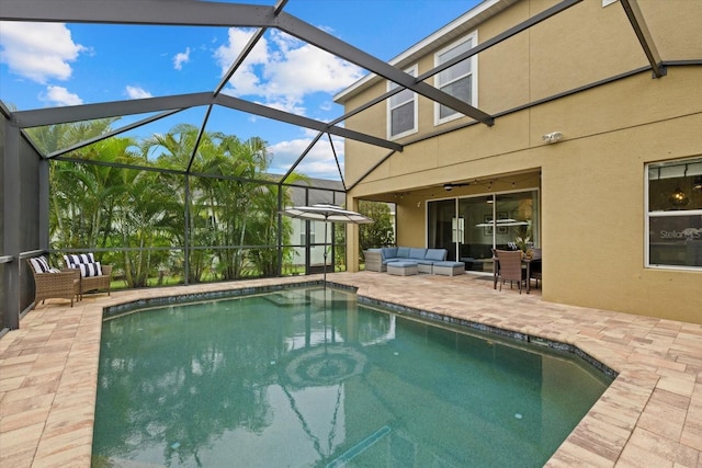 outdoor pool with a ceiling fan, a lanai, a patio area, and an outdoor hangout area