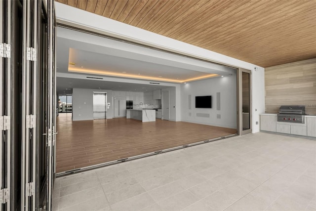 interior space featuring light hardwood / wood-style floors, wood ceiling, and a raised ceiling