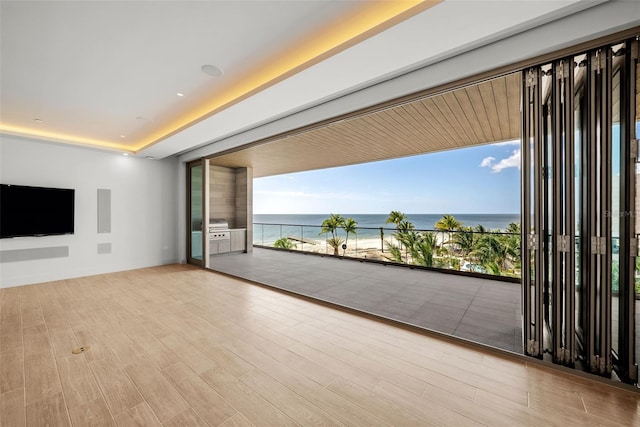 unfurnished living room with a water view and light hardwood / wood-style flooring