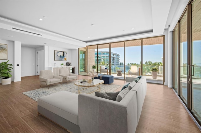 living room featuring floor to ceiling windows, hardwood / wood-style flooring, and plenty of natural light