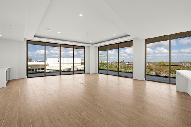 interior space with light hardwood / wood-style flooring, floor to ceiling windows, and plenty of natural light