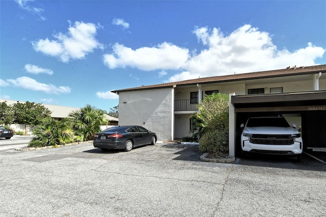 view of front of house featuring a balcony and a carport