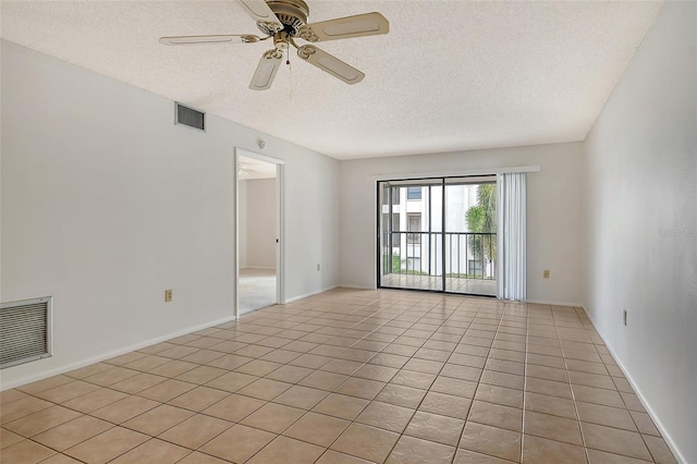 tiled spare room with ceiling fan and a textured ceiling