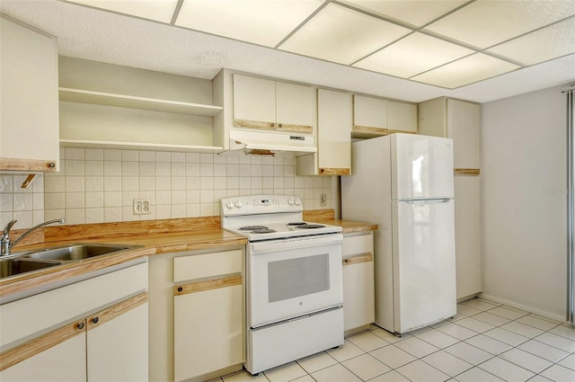 kitchen featuring light tile patterned flooring, wooden counters, backsplash, sink, and white appliances