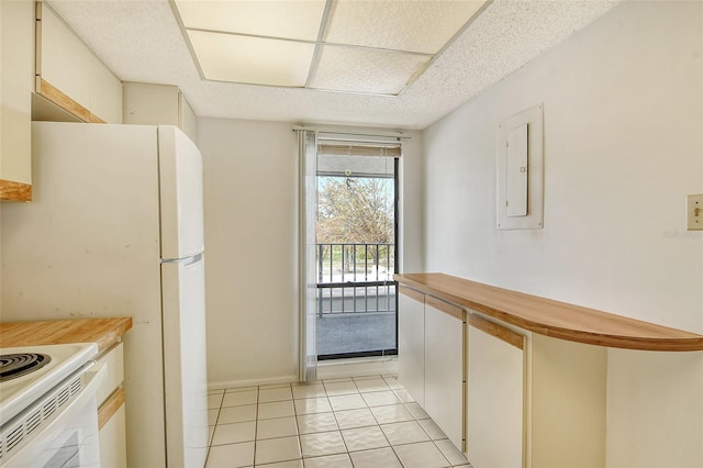 kitchen with electric panel, butcher block counters, a textured ceiling, light tile patterned floors, and white cabinets