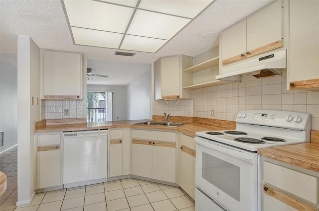 kitchen featuring wooden counters, sink, light tile patterned floors, ceiling fan, and white appliances