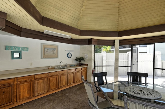 kitchen with high vaulted ceiling, sink, wooden ceiling, and dark carpet