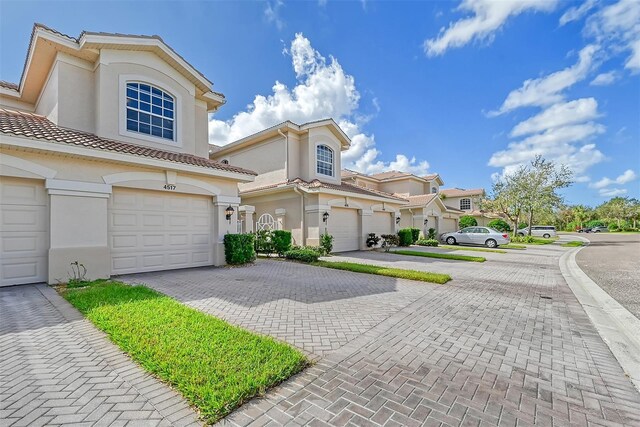 4517 Streamside Ct Unit 1905, Sarasota, FL 34238 - townhome / multi-family property featuring stucco siding, driveway, a tiled roof, and a garage