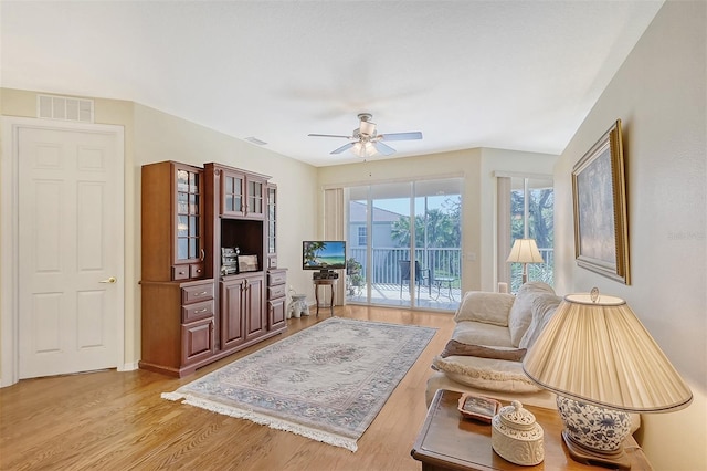 living room with ceiling fan and light hardwood / wood-style flooring