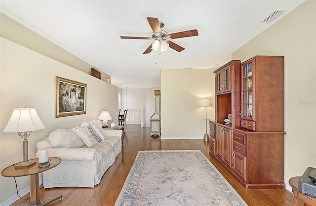 living room with ceiling fan and dark hardwood / wood-style floors