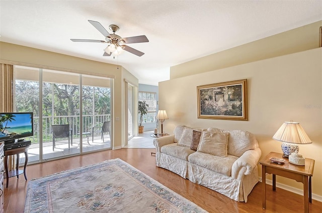 living room with wood-type flooring and ceiling fan