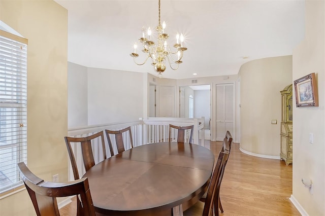 dining space with light wood-type flooring and a chandelier