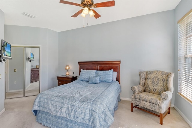 bedroom with a closet, light colored carpet, and ceiling fan