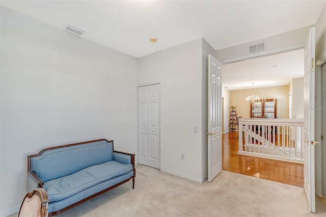 living area with light carpet and a notable chandelier