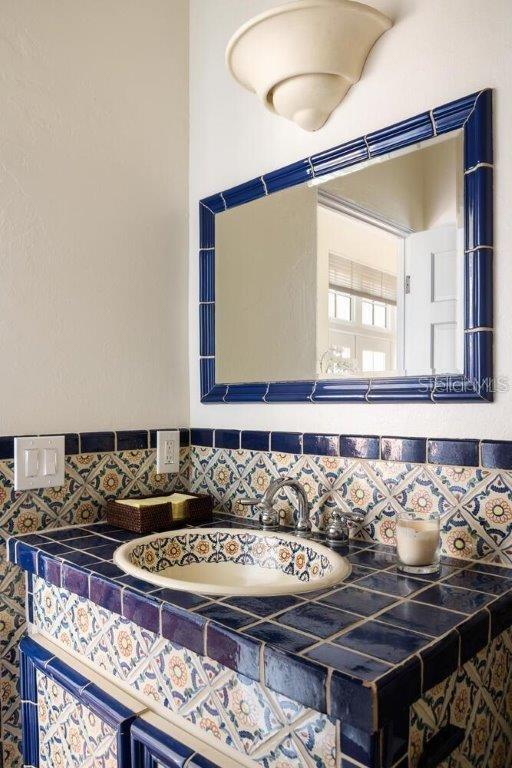 bathroom with sink and decorative backsplash