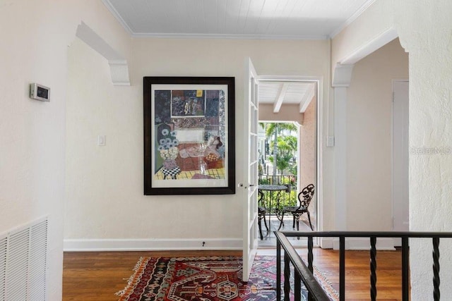 hallway with wood-type flooring and ornamental molding