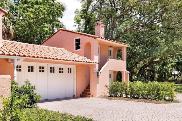 4511 Bay Shore Rd, Sarasota, FL 34234 - mediterranean / spanish-style home with decorative driveway, an attached garage, a chimney, and a tile roof