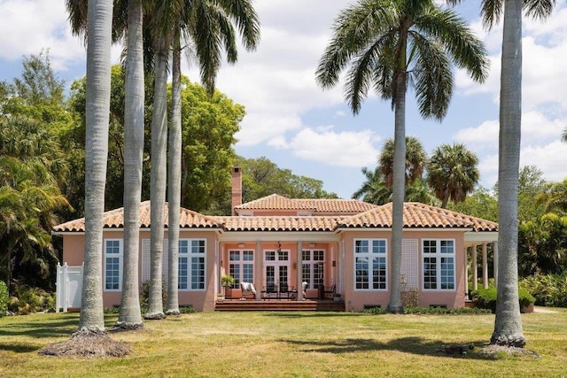 rear view of property featuring french doors, a yard, and a deck