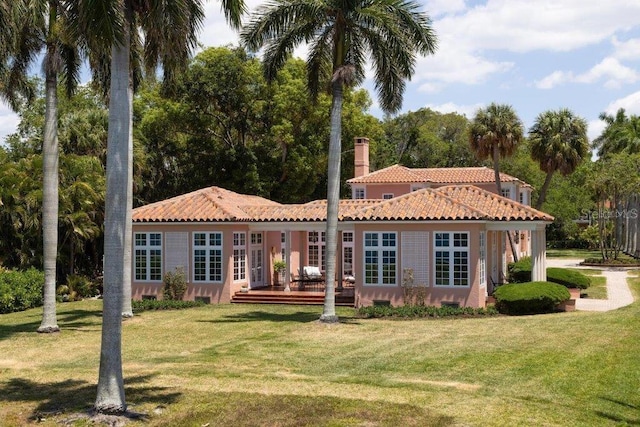 back of property with a wooden deck and a yard