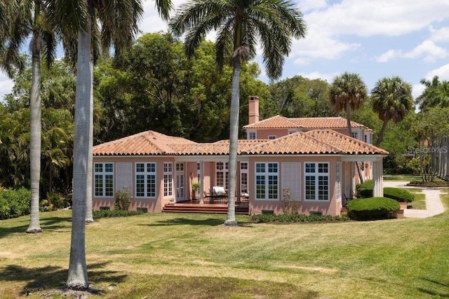 4511 Bay Shore Rd, Sarasota, FL 34234 - back of house with a tiled roof, a deck, a yard, and a chimney