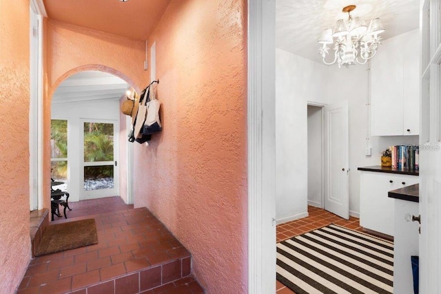 4511 Bay Shore Rd, Sarasota, FL 34234 - hallway featuring arched walkways, a chandelier, and a textured wall