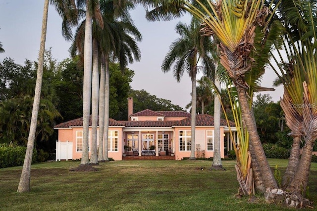 4511 Bay Shore Rd, Sarasota, FL 34234 - rear view of property with a yard, a tile roof, and stucco siding