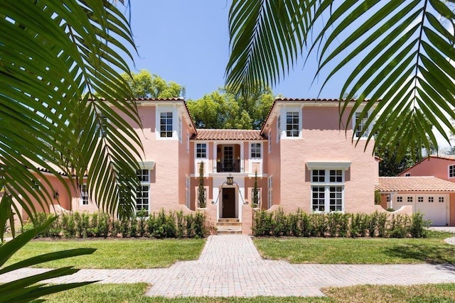 view of front of house with a balcony and a front lawn