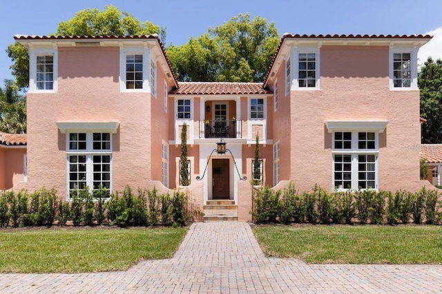 mediterranean / spanish-style home with a balcony and a front yard