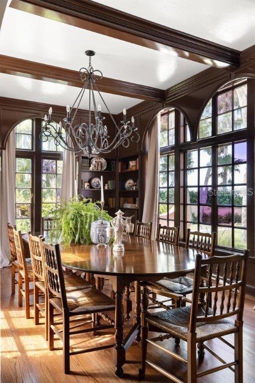 dining room featuring a healthy amount of sunlight, hardwood / wood-style floors, an inviting chandelier, and french doors