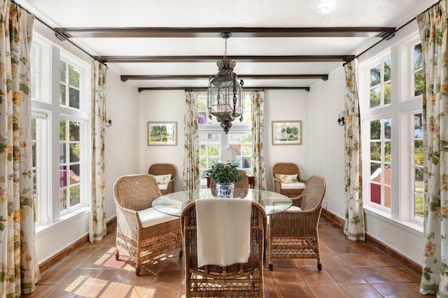 tiled dining area featuring a notable chandelier and beamed ceiling