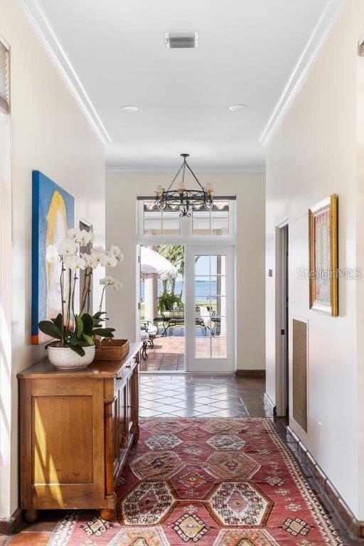 interior space with crown molding and a chandelier