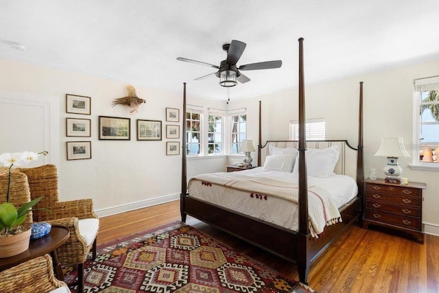 bedroom with multiple windows, wood-type flooring, and ceiling fan