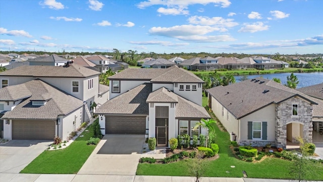 view of front facade featuring a water view, a garage, and a front lawn