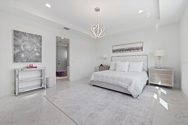 bedroom featuring ensuite bathroom and a notable chandelier