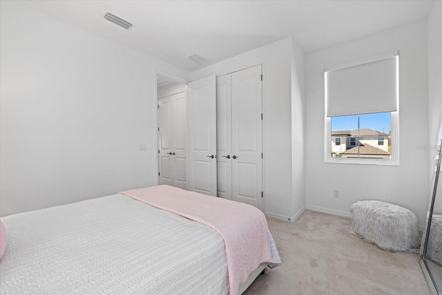 bedroom with light carpet and a closet