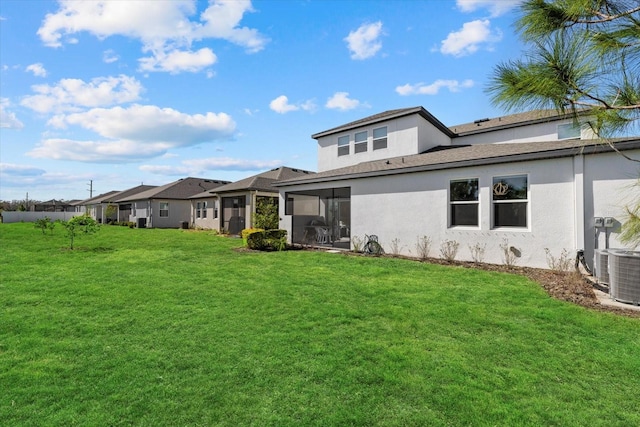 back of house featuring a lawn, central AC, and a sunroom