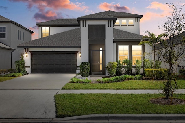 view of front facade with a garage and a lawn