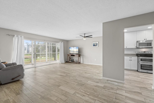 living room with ceiling fan, light hardwood / wood-style floors, and a textured ceiling