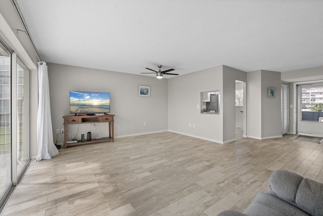 unfurnished living room with a textured ceiling, light wood-type flooring, and ceiling fan